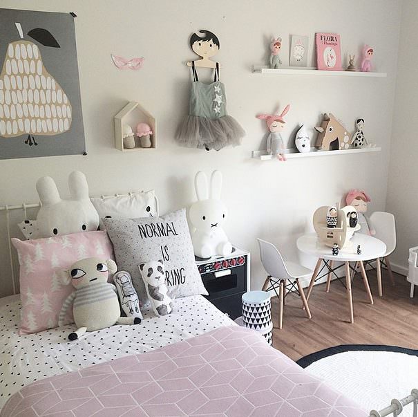 اتاق دختر بچه ای با قفسه های عروسکی و دکوری که در دکوراسیون آن از میز و صندلی های کوچک کودکانه استفاده شده است